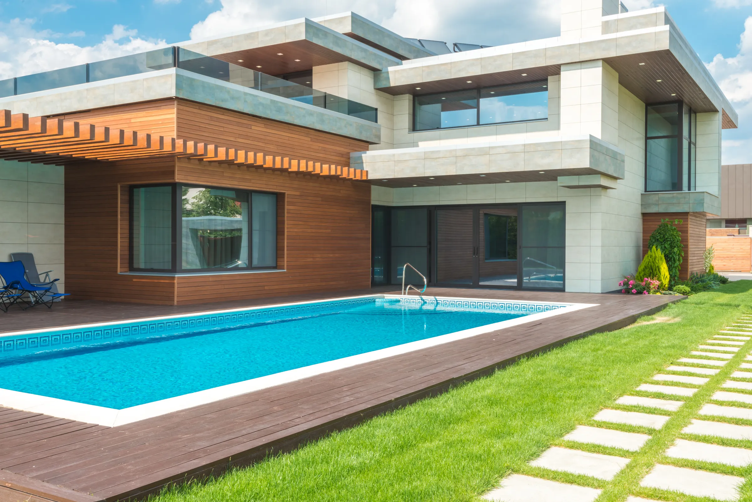 Arquitetura residencial contemporânea com madeira, grandes janelas e piscina — imagem institucional